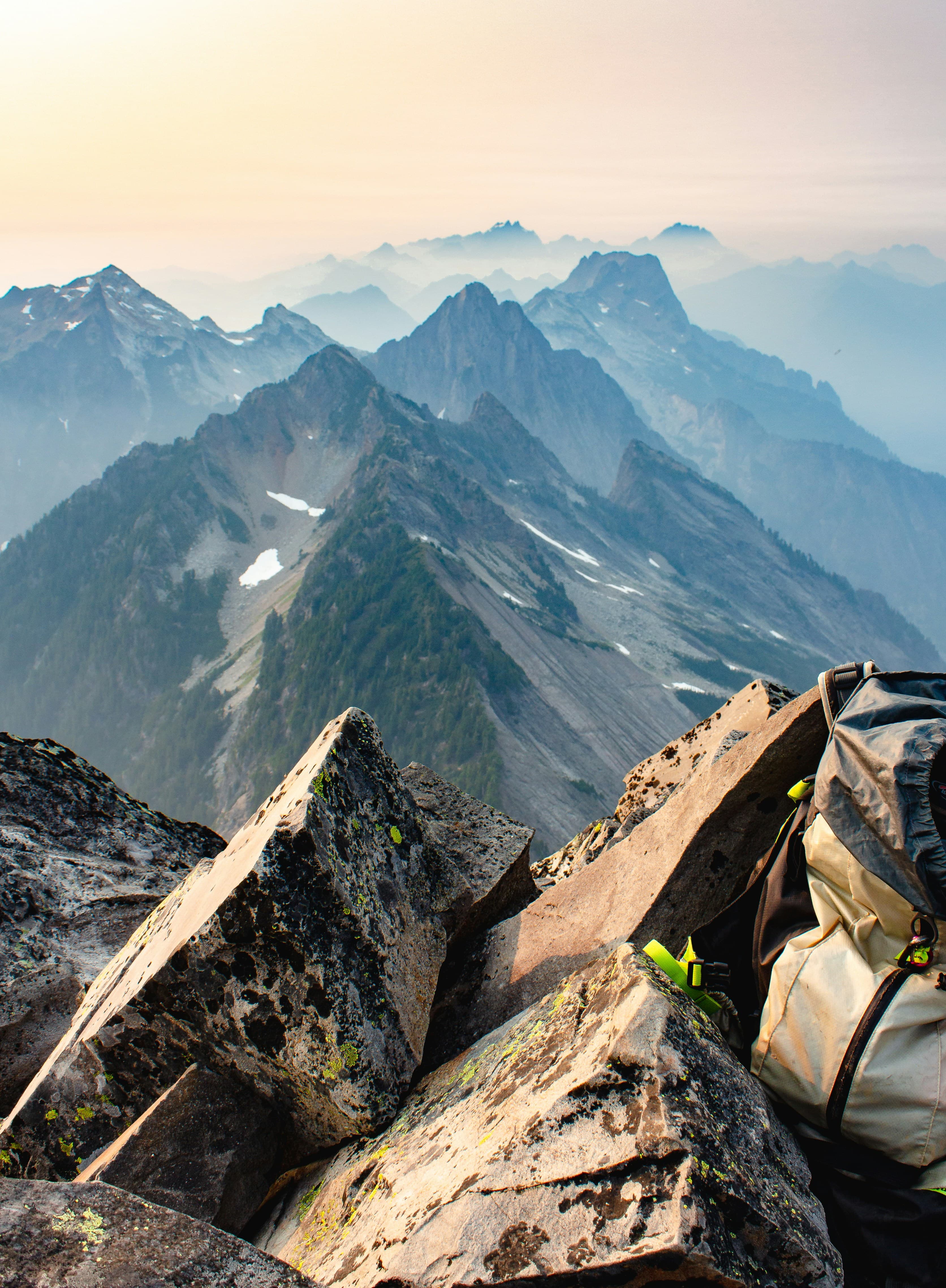 Hiker with backpack traversing a mountain trail at sunrise